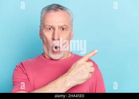Photo portrait senior man amazed pointing finger blank space choosing isolated pastel blue color background Stock Photo