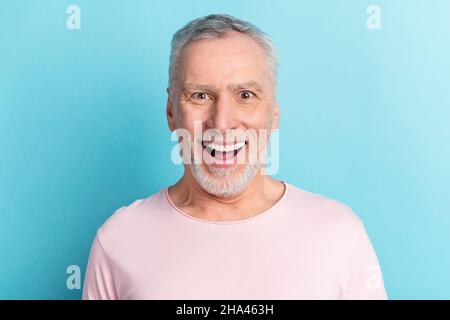 Photo portrait smiling man in pink t-shirt staring surprised overjoyed isolated on pastel blue color background Stock Photo