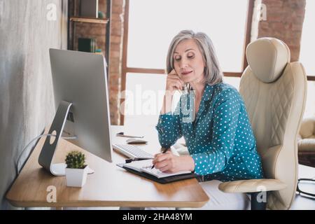 Profile side photo of elderly business woman sit office desk concentrated write notebook plan to-do list Stock Photo