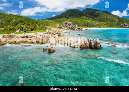 old coral reef in the white sand beach on secluded beach of grand anse,la digue,seychelles. aerial view. Stock Photo