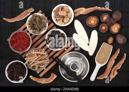 Chinese moxibustion treatment with moxa sticks, herbs and spice used in traditional herbal plant medicine. Natural health care concept. On bamboo back Stock Photo