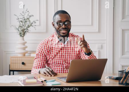 Cheerful Afro-American male English language tutor having remote classes online Stock Photo