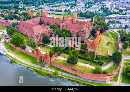 Aerial panoramic view of the gothic Grand Masters’ Palace in the High Castle part of the medieval Teutonic Order Castle by the Nogat river in Malbork, Stock Photo
