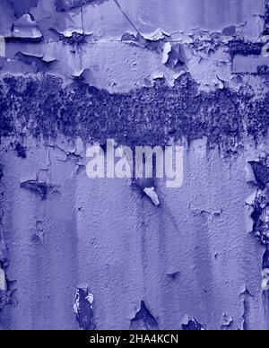Dark rusty metal surface with corrosion and cracked blue Very Peri color paint texture background. Stock Photo