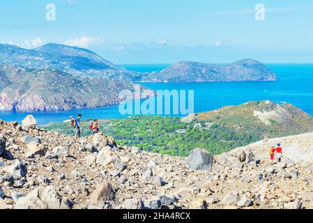 Hikers walking around Gran Crater rim, Vulcano Island, Aeolian Islands, Sicily, Italy Stock Photo