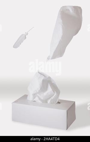 tissues floating out of a tissue box on a white background Stock Photo