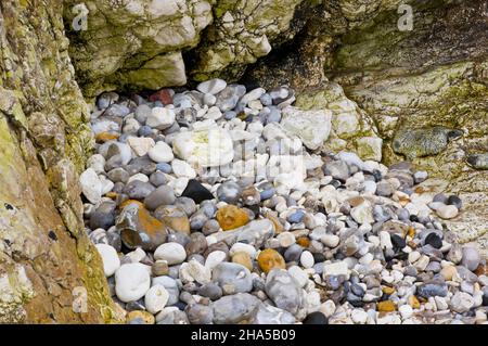 europe,northern ireland,county antrim,causeway coast,limestone cliffs with colorful pebbles on the coast at portrush Stock Photo
