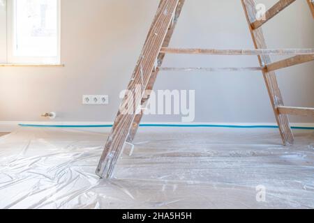 construction site,redevelopment and renovation of an apartment,painter's ladder on a floor covered with foil Stock Photo
