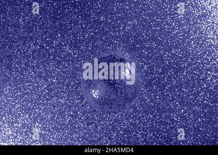 Abstract gradient glitter with Christmas glass bauble. Toned in trendy color of year 2022. Christmas and New Year concept in flat lay style. Copy space. Stock Photo