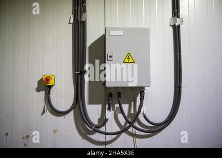 An electric shield with wires connected to it in a corrugated pipe Stock Photo