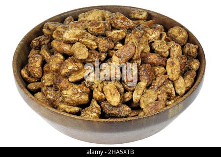candied peanuts in a wooden bowl isolated on white background Stock Photo