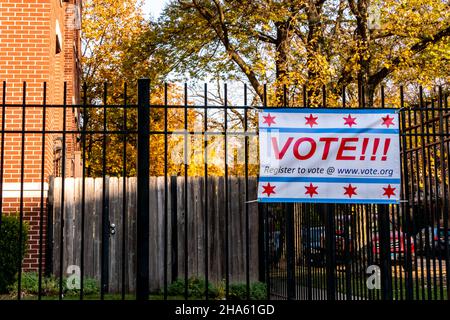 Register to Vote banner affixed to a black wrought iron fence, in a residential neighborhood. Stock Photo