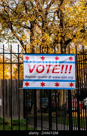 Register to Vote banner affixed to a black wrought iron fence, in a residential neighborhood. Stock Photo