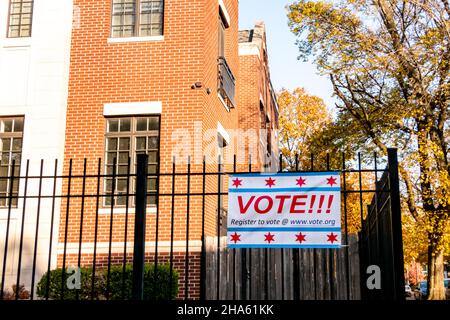 Register to Vote banner affixed to a black wrought iron fence, in a residential neighborhood. Stock Photo