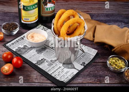 Oven baked breaded calamari rings, on serving board, on white stone