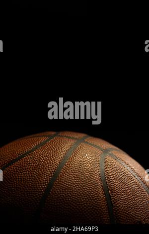 Detail of orange basketball ball with black background. Stock Photo