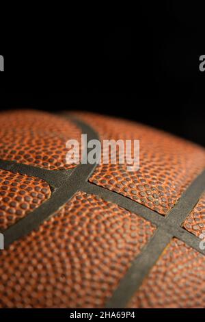 Detail of orange basketball ball with black background. Stock Photo