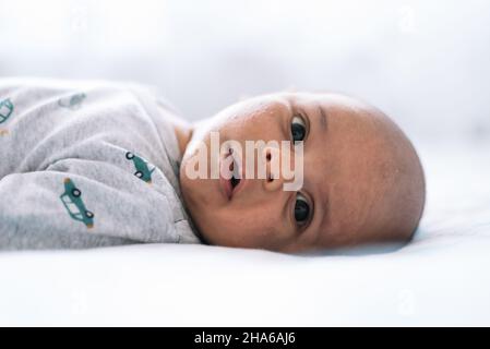 One-month-old baby lying in bed Stock Photo