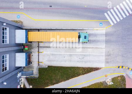 Aerial Side Shot of Industrial Warehouse Loading Dock where Man Stock Photo