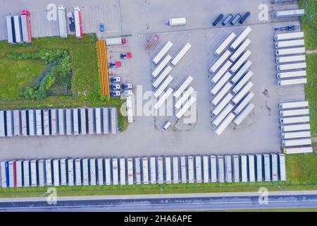 Aerial top view of white cargo trailer parking, trailer line up. Delivery, logistics. Stock Photo