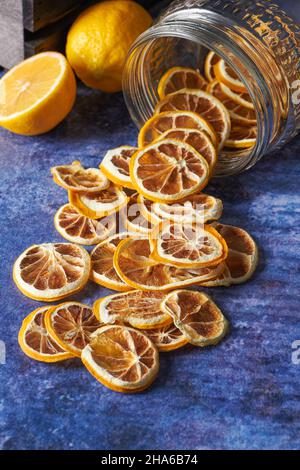 Dried Lemon and Orange Slices Falling Inside From a Jar. Dried Fruit Concept Stock Photo