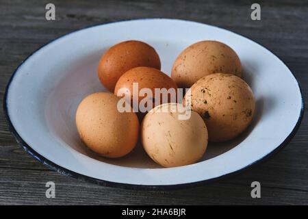 A dish with homegrown fresh kitchen eggs with dirt on the shell Stock Photo