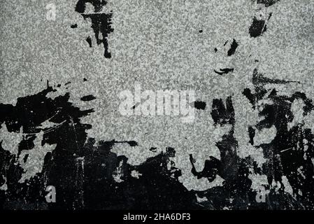 Old metal plate with worn out black paint stains, grunge background or texture Stock Photo