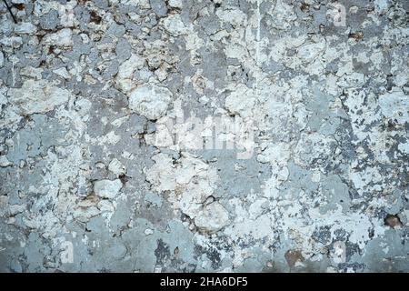 Old traditional limewashed stone wall with peeling plaster, white rustic background or texture Stock Photo