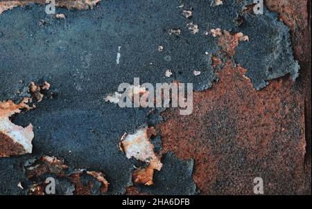 Old rusty metal sheet with peeling dark blue paint, grunge background or texure Stock Photo
