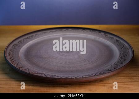 Brown plate on a wooden surface. Stock Photo