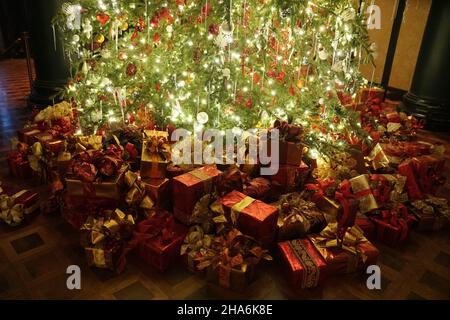 Beautifully wrapped of gifts under the Christmas tree with lights Stock Photo