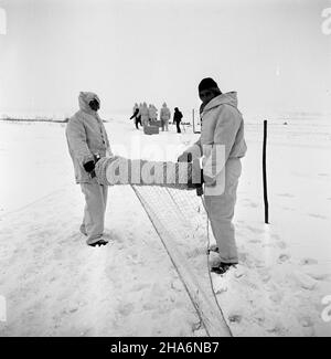 Pisz, 1969-12. Pracownicy Przedsiêbiorstwa Las z Olsztyna od³awiaj¹ ¿ywe zaj¹ce przeznaczone na eksport (m.in. do Francji i W³och). Nz. rozwijanie sieci. kw  PAP/Stanis³aw Moroz  Dok³adny dzieñ wydarzenia nieustalony.      Pisz, Dec. 1969. Workers of the Las Enterprise in Olsztyn are living hare hunting. The animals were exported to France, Italy and other countries. Pictured: spreading a net.  kw  PAP/Stanislaw Moroz Stock Photo