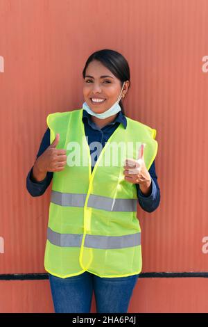 Portrait of a Hispanic female construction worker wearing a protective mask Stock Photo