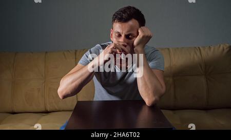 Young tipsy man drinks alcohol trying to solve problems Stock Photo