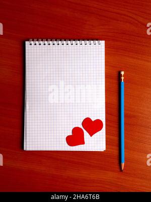 Blank Writing Pad with Heart Shapes and Pencil On The Table Stock Photo