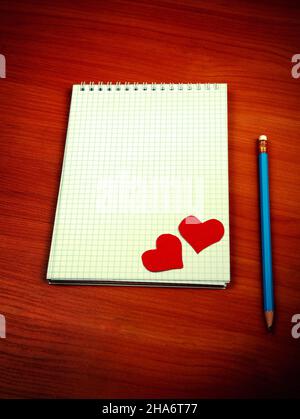 Toned Photo of Blank Writing Pad with Heart Shapes and Pencil On The Table Stock Photo