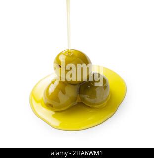 The moment when olive oil is poured over olives placed on a white background Stock Photo