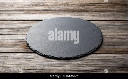 Stone plate placed on a wooden background, concept for composition Stock Photo