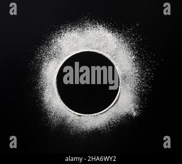 Abstract background. Black background with round dots sprinkled with flour circles. Top view Stock Photo