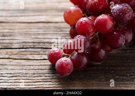Red Globe of grapes set against a wooden background. Stock Photo