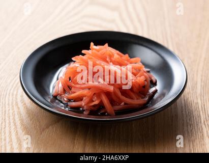 Red pickled ginger on a wooden table. Image of red pickled ginger in Japan. Stock Photo