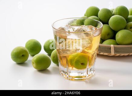 Japanese plum wine and unripe plums on a white background. Stock Photo
