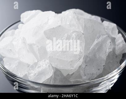 rock candy in a glass bowl set against a black background. Stock Photo