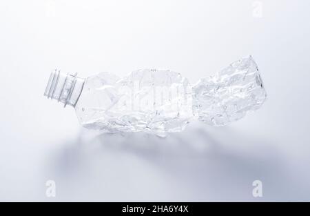 A crushed plastic bottle on a white background. Concept of recycling and ecology. Stock Photo