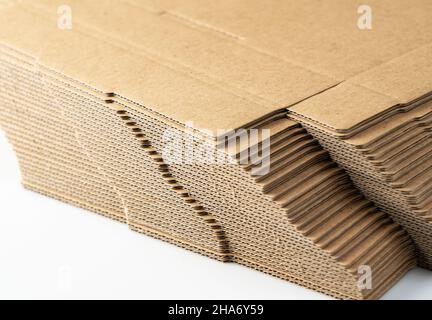 A lot of pre-assembled cardboard boxes stacked on a white background. Shipping concept Stock Photo