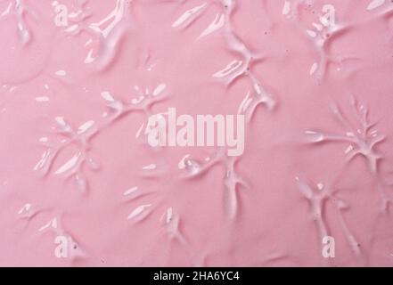 Serum texture on transparent liquid gel background with pink background.  Transparent beauty skin care product sample. Stock Photo