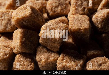 Brown cane sugar cubes all over the screen. Close-up Stock Photo