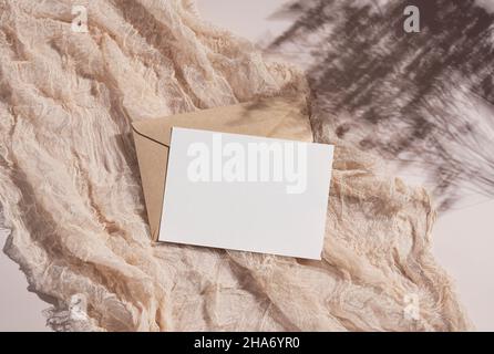 Summer wedding stationery mockup. Beige background with plain greeting cards, invitations and gauze fabric. Natural light and shadow overlay. Flat lay Stock Photo