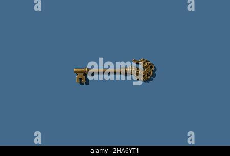 Retro key with brass seahorse placed on a blue background. View from directly above. Stock Photo