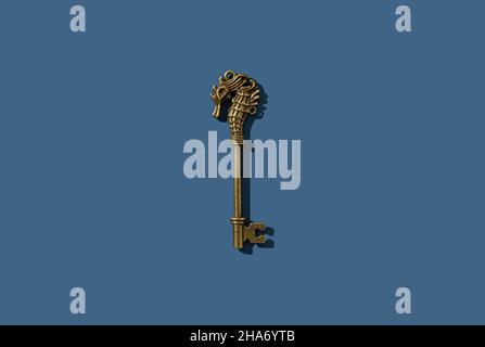 Retro key with brass seahorse placed on a blue background. View from directly above. Stock Photo